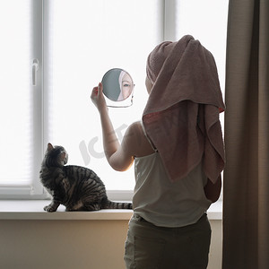 在享受的猫摄影照片_年轻女子和她可爱的猫在家里。