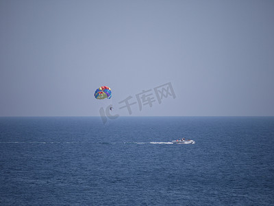 彩色降落伞延伸至船绳，为海上游客提供娱乐