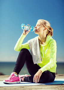 女人在户外运动后喝水