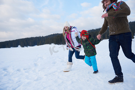 冬天幸福的一家人一起在雪地里玩耍