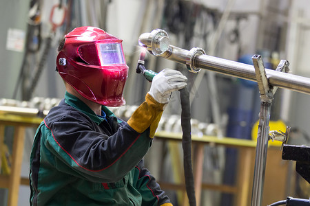 焊接工人摄影照片_金属工厂的产业工人焊接。