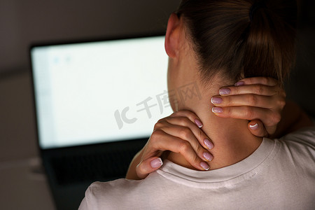 年轻女子在电脑前工作后患有颈部疼痛。