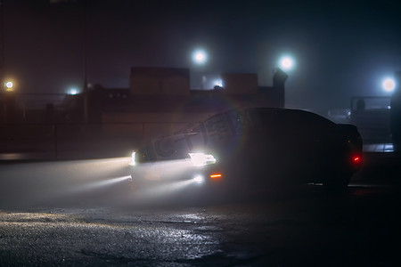 运动车在阴影中，在雾夜的低光下发光，或运动车深色背景的轮廓。
