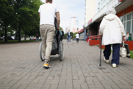 男子驾驶轮椅的残疾妇女过马路、步行、购物