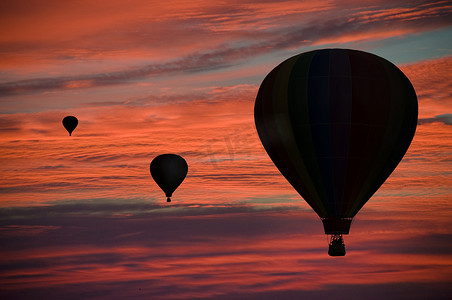 气球上升摄影照片_黎明时分，热气球漂浮在云层中