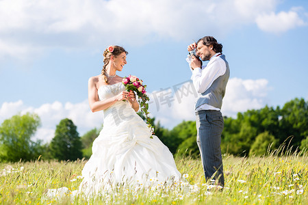 新婚图片摄影照片_新婚夫妇在草地上拍照