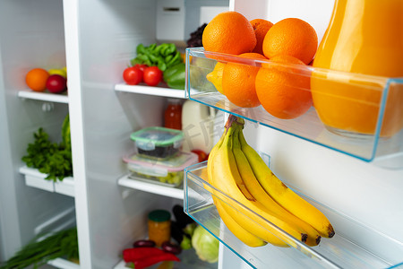 室内冰箱摄影照片_打开冰箱，里面装满了水果、蔬菜和饮料