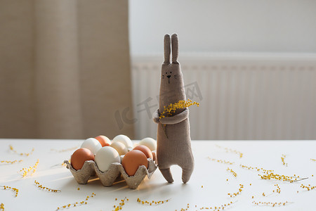 有趣的手工制作小兔子玩具，配有彩色鸡蛋和黄色含羞草花。