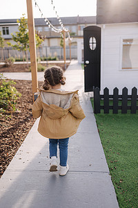 小女孩在小孩城市散步的后视图。