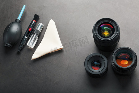 相机特写摄影照片_用于在深色纹理背景上清洁带有镜头的相机的工具。