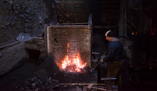 年轻的传统铁匠用明火工作