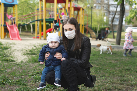 一名妇女和她的儿子戴着防护面具，抵御冠状病毒或该市爆发的 covid-19 和 pm 2.5 病毒的肖像。