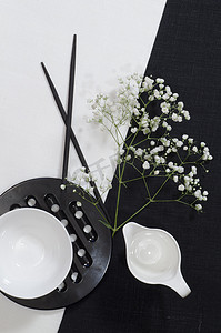 黑白火柴人摄影照片_黑白亚麻桌布上的白色瓷器。
