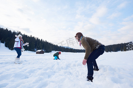 冬天幸福的一家人一起在雪地里玩耍