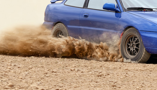 汽车沙漠摄影照片_拉力赛车在土路上漂流。