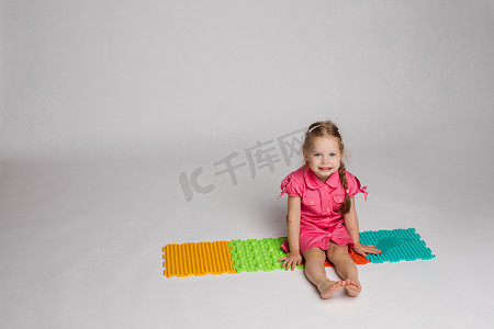 小女孩玩扁平橡胶垫。