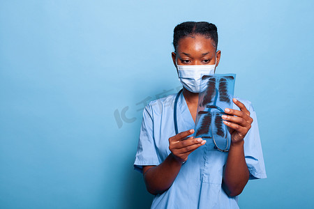 放射防护摄影照片_带防护医用面罩的非裔美国医师助理