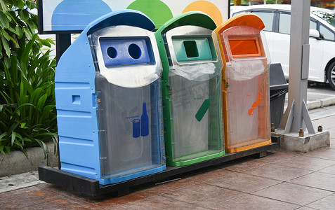 绿色城市垃圾分类摄影照片_处置前将垃圾分类到回收箱中。