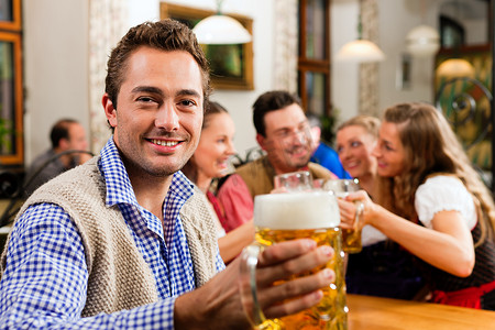 喝啤酒摄影照片_在巴伐利亚酒吧喝啤酒的男人