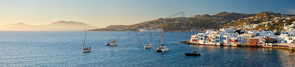 希腊米科诺斯岛的日落，港口有游轮和游艇