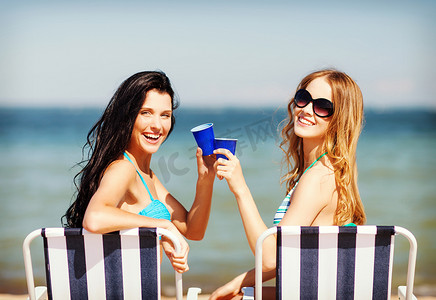 喝饮料的女孩摄影照片_沙滩椅上喝饮料的女孩