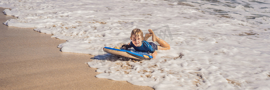 快乐的小男孩在度假时在海滩上玩得开心，带着布吉板横幅，长格式