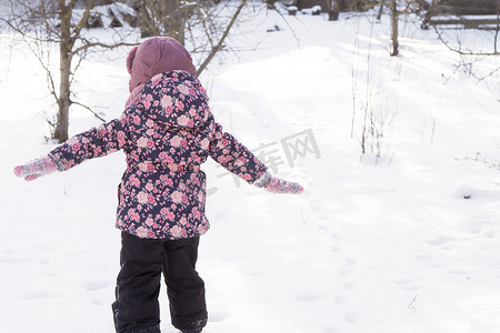 冬天、家庭、童年概念 — 正宗的学龄前小女孩在雪天寒冷的公园里散步。
