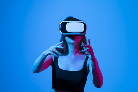 vr虚拟现实摄影照片_戴着虚拟现实耳机的女工程师利用 VR 技术设计新产品或技术。
