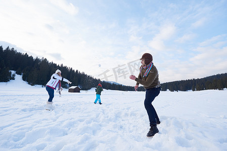 雪地里玩耍摄影照片_冬天幸福的一家人一起在雪地里玩耍