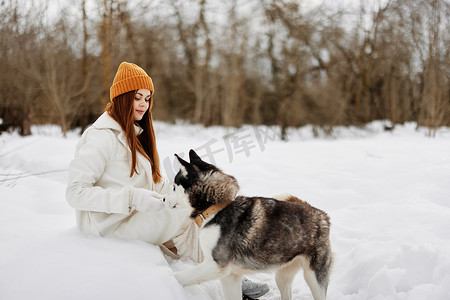 女人冬衣在雪地新鲜空气中遛狗