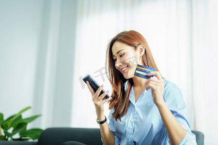 网上购物和互联网支付，亚洲女性的肖像正在使用手机和信用卡在数字世界中网上购物或办事。