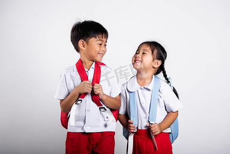 小学生裤子摄影照片_两个亚洲学生孩子女孩男孩小学生兄弟姐妹微笑快乐穿学生泰国制服红色裤子裙子