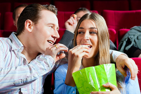 情侣在电影院里吃爆米花