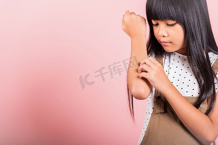 10 岁的亚洲小孩因蚊子叮咬而抓痒手臂