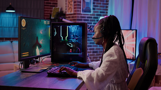 非洲裔美国玩家女孩使用电脑游戏设置玩多人太空射击模拟游戏，玩得很开心