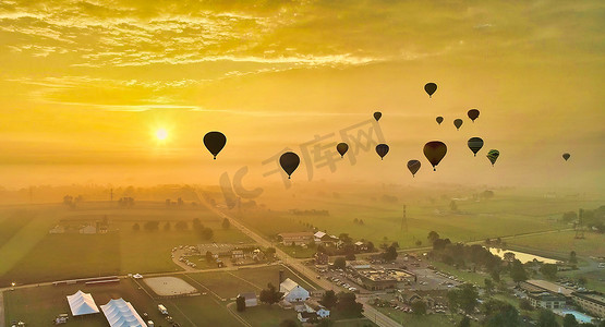 清晨许多热气球飞入阳光和薄雾的鸟瞰图