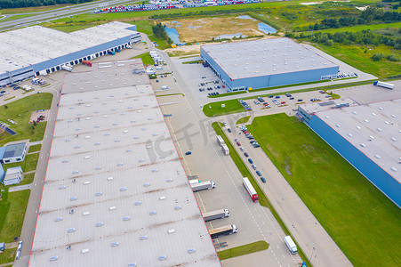 货车仓库摄影照片_工业仓库装货码头的空中拍摄，许多卡车与半拖车装载商品。