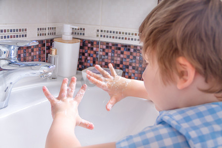 特写孩子洗手并展示肥皂手掌。