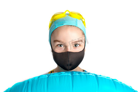 一个戴着黑色防护面具和一个充气绿松石游泳圈的女孩。