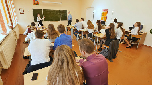 教室白板摄影照片_教室里的学生都坐在自己的课桌前。