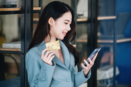 网上购物和网络支付，美丽的亚洲女性正在使用手机和信用卡在数字世界中网上购物或办事。