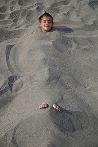 快乐的孩子们埋在沙子里