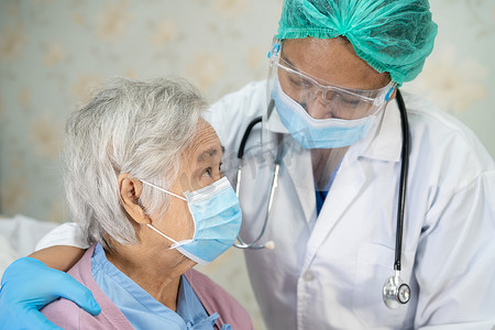 医生在医院检查戴口罩的亚洲老年或老年老妇患者，以防止感染 Covid-19 冠状病毒。