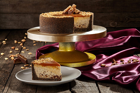 马斯卡彭摄影照片_切片芝士蛋糕，配巧克力屑、花生和焦糖