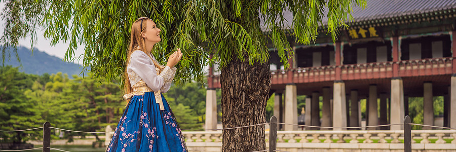 韩服女摄影照片_身着韩服的年轻白人女游客去韩国旅游的概念。