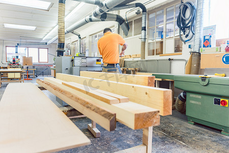 木匠或细木工在他的工作室里加工原木