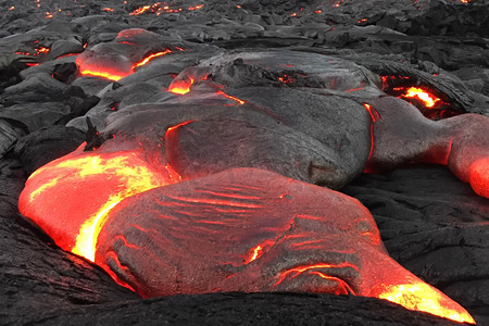 热熔摄影照片_熔岩倾泻在火山的斜坡上。
