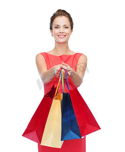 红色主义摄影照片_穿着裙子、提着购物袋的微笑优雅女人