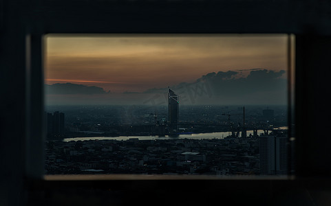 华丽灯光背景摄影照片_华丽的日出或日落全景，曼谷市的鸟瞰图，俯瞰摩天大楼和横跨湄南河的桥梁，闪烁着明亮的灯光。