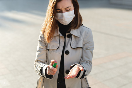 人们使用酒精消毒凝胶并戴上预防性口罩可以预防感染 Covid-19 冠状病毒的爆发，一名妇女洗手。